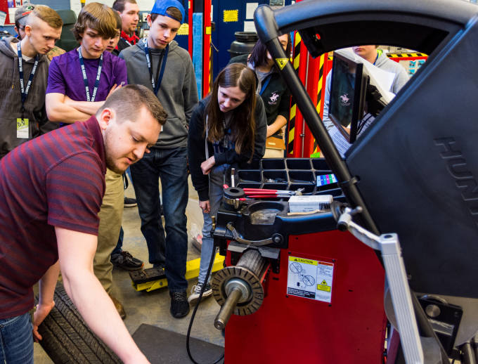 a group of people looking at a machine