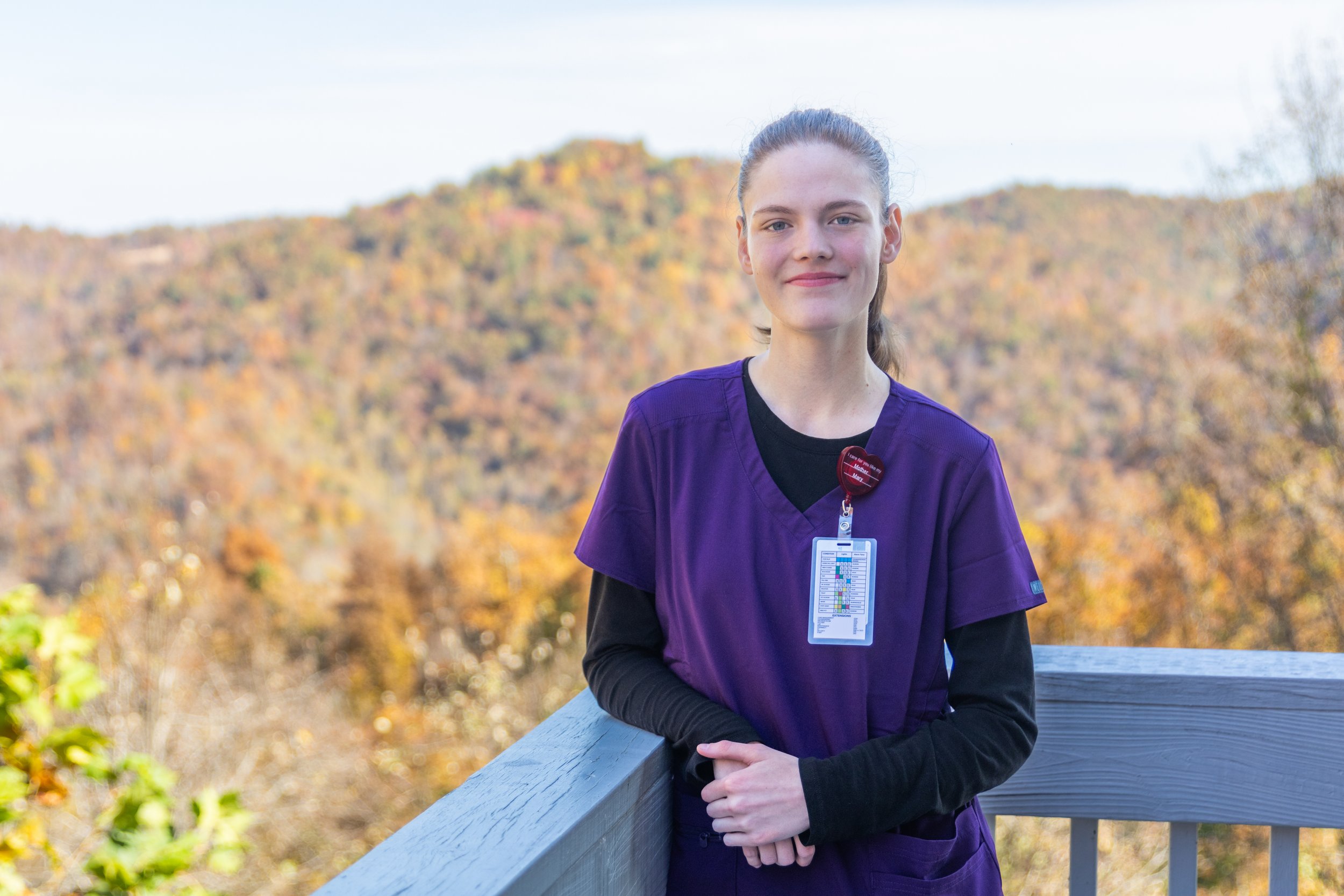 a person standing on a railing with a mountain in the background