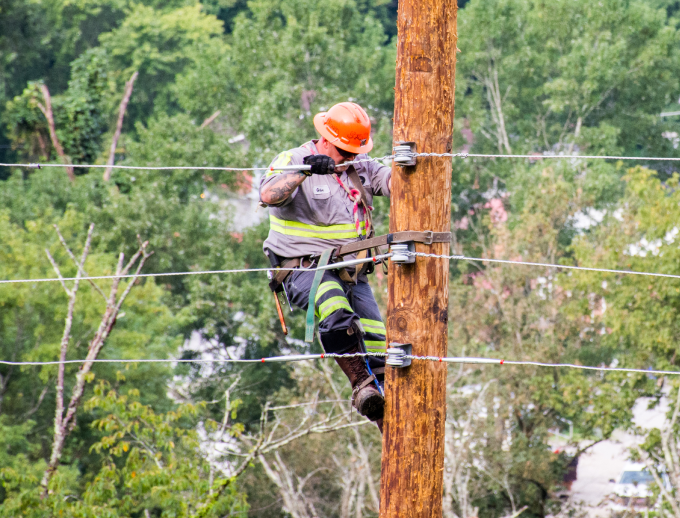 a person climbing on a telephone pole