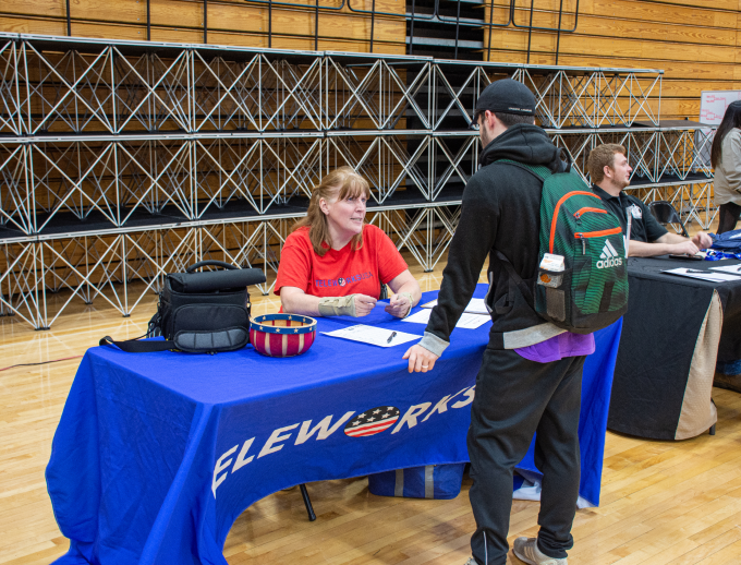 a person standing next to a person signing a document