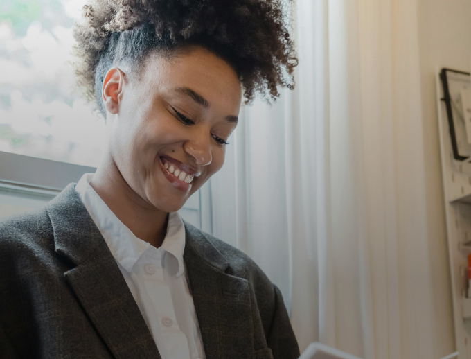 a person smiling at a cellphone