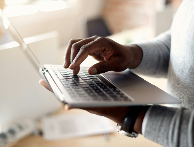 Hands typing on a laptop