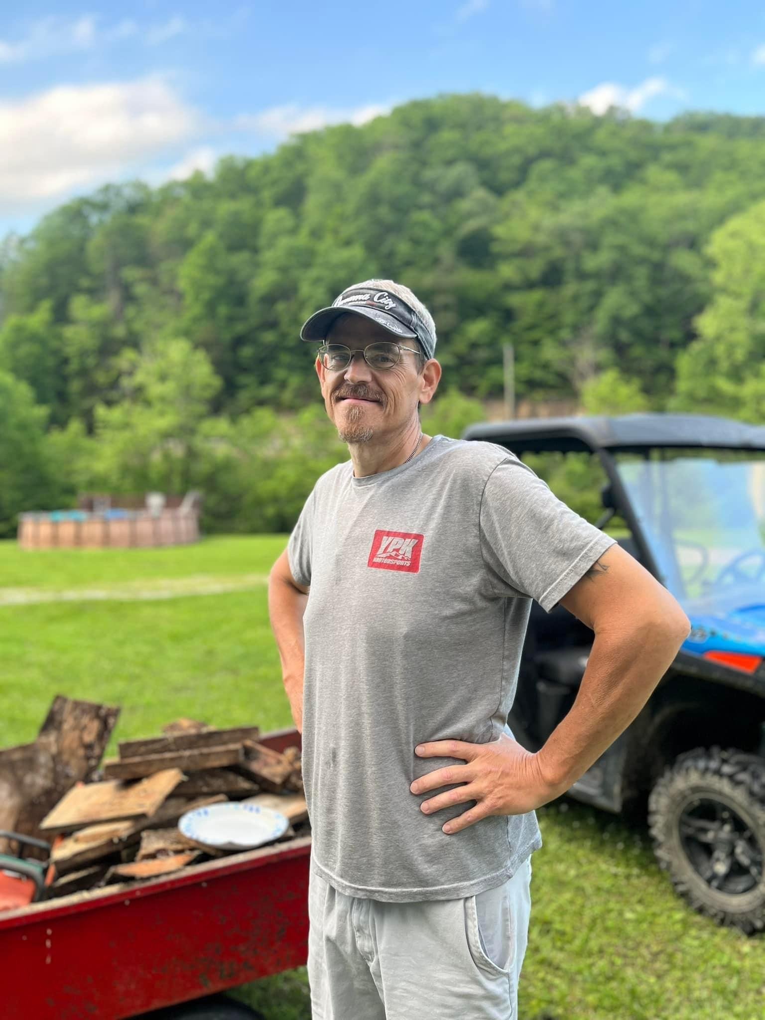 a person standing in front of a pile of wood