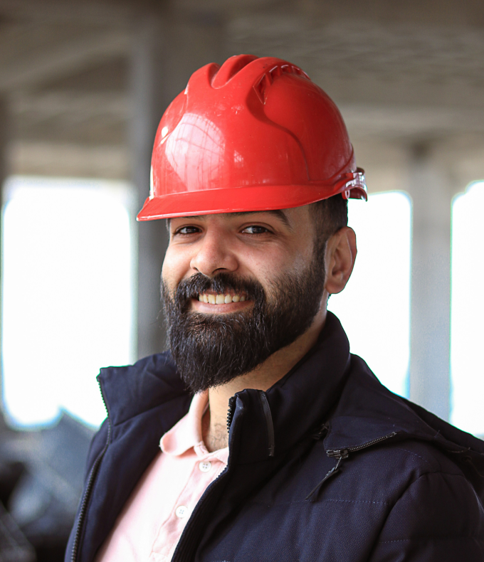 A man with a beard and a red helmet, ready for partnership with a business