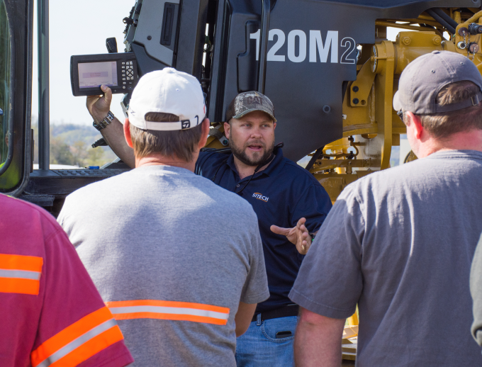 a group of people standing around a machine